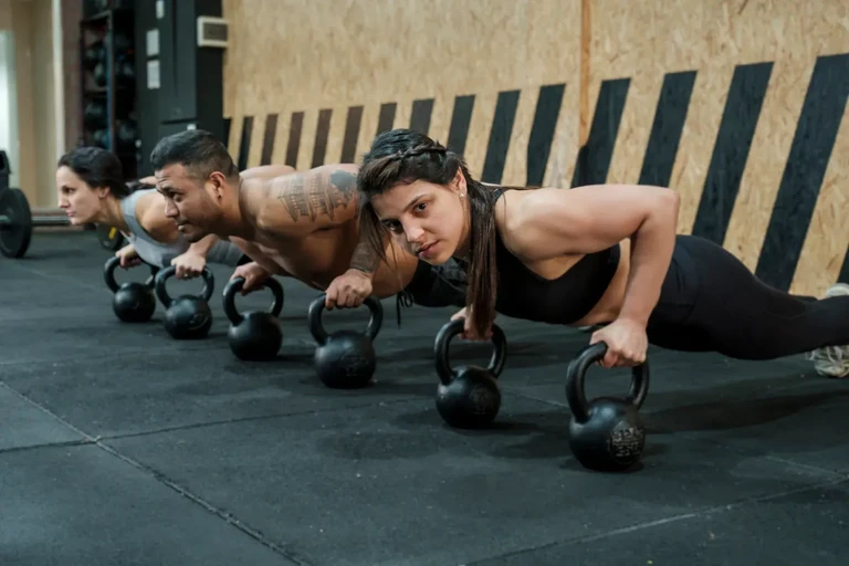 Grupo de personas haciendo ejercicios de plancha en un gimnasio