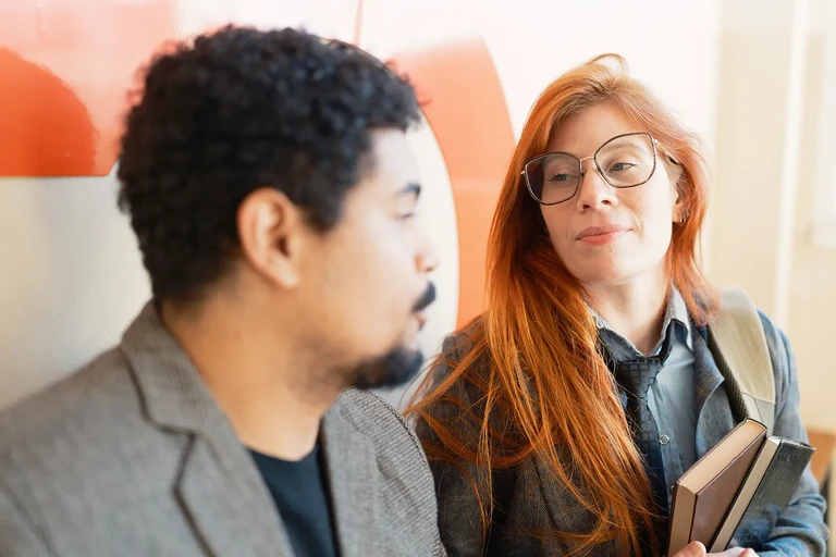 Pareja en reunión de trabajo casual sosteniendo una libreta