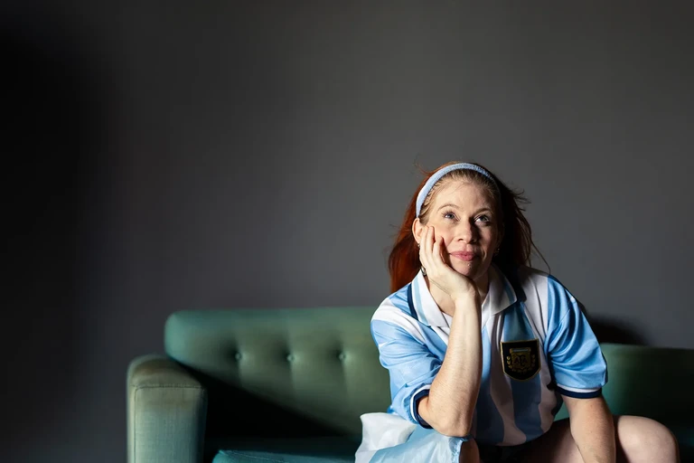 Mujer sonriendo relajada en un sillón verde