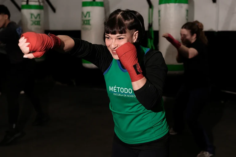 Mujer con guantes de boxeo verdes lista para entrenar